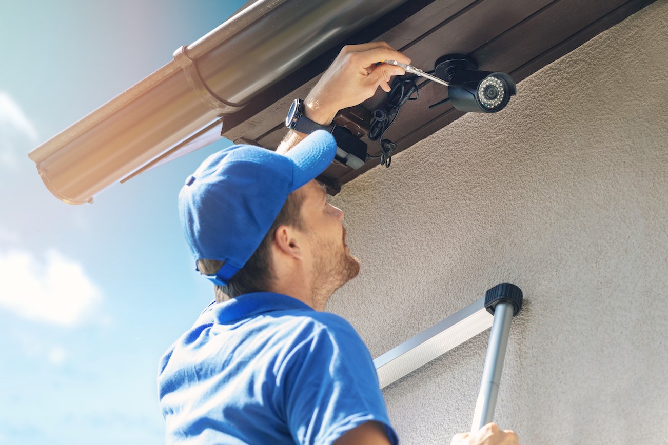A surveillance camera is installed by a security professional
